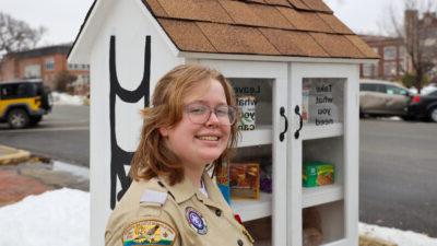 Young woman standing in front of outdoor pantry